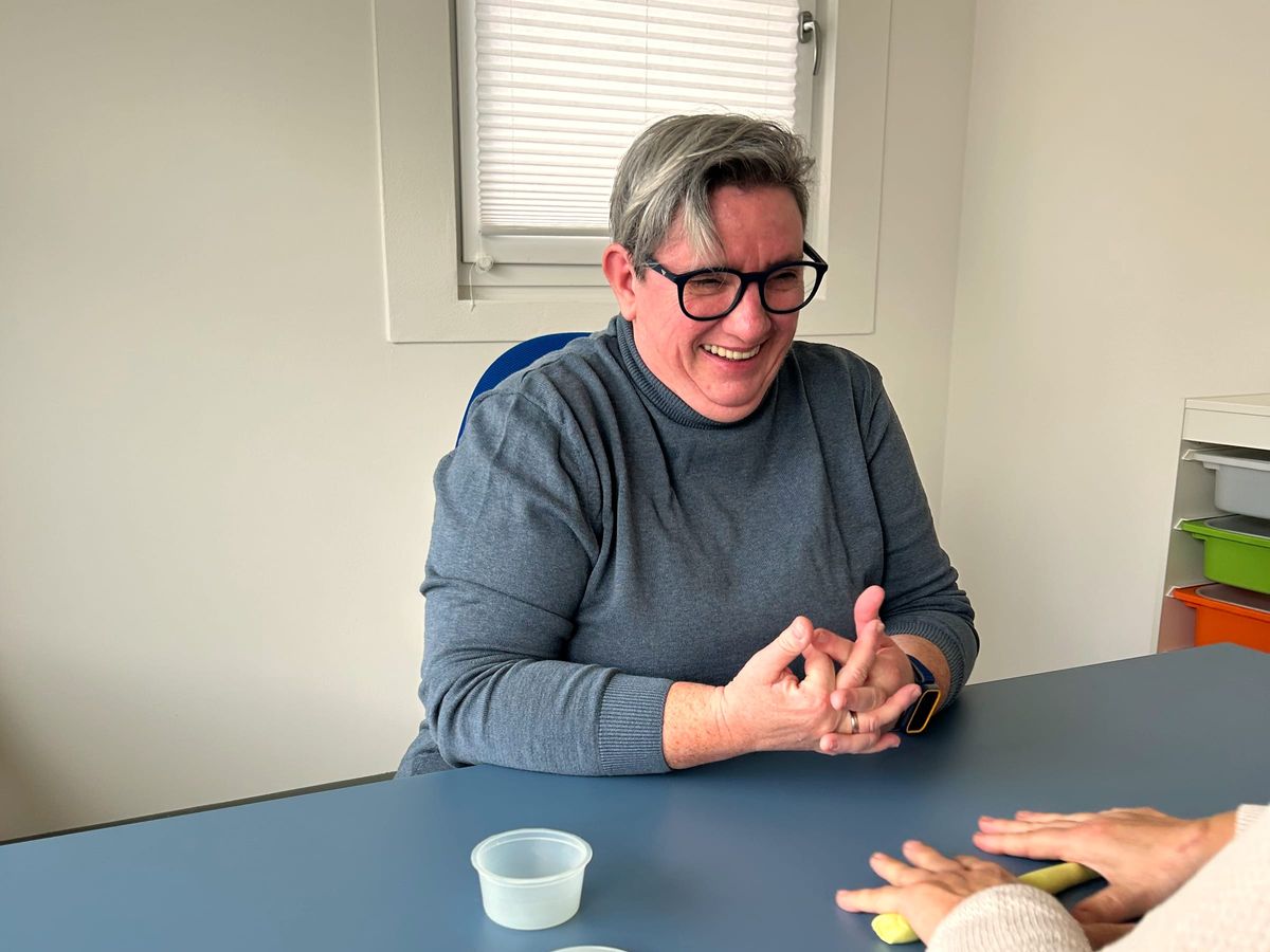 Susanne Aigner lacht bei der Arbeit am Therapietisch
