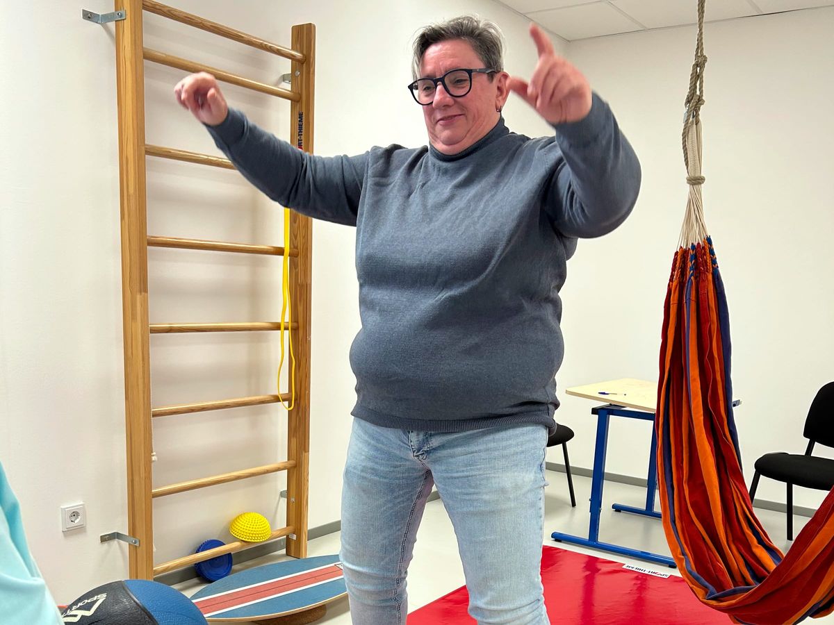 Bewegungsübung mit Schwung im Bewegungsraum mit Sprossenwand und Hängematte