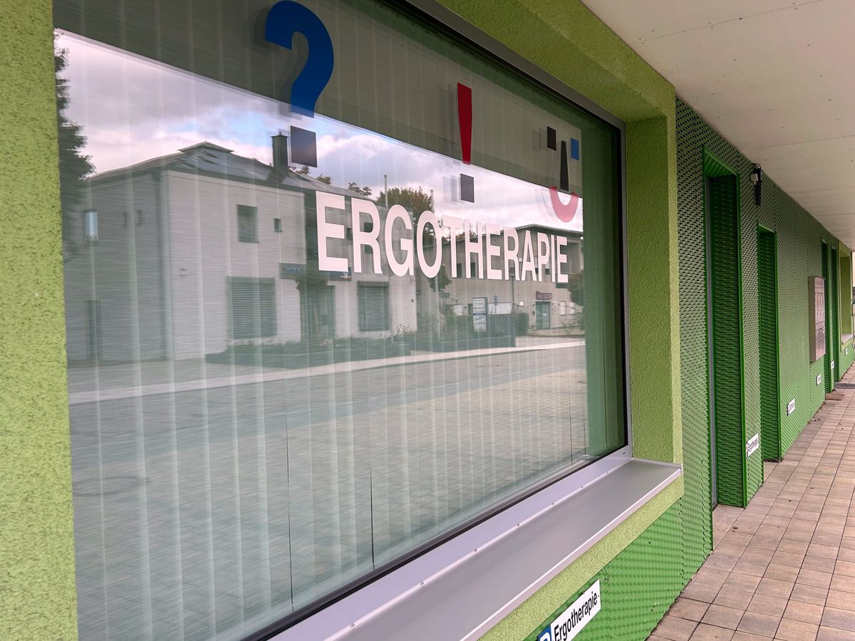 Eingang der Praxis in der Bruckdorfer Straße 9 mit Logo im Schaufenster