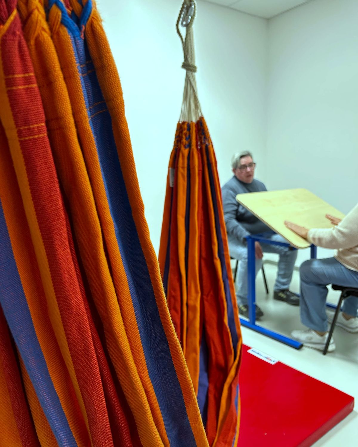 Hängematten im Bewegungsraum, dahinter Arbeit am Schrägtisch